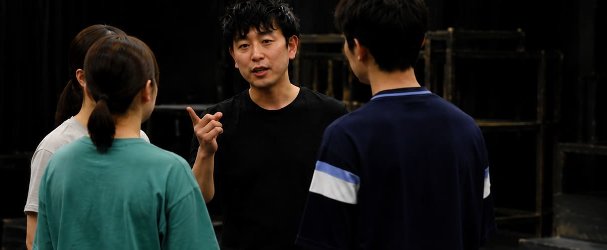 稽古場で俳優に演技指導を行う松野正史