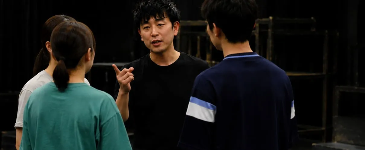 稽古場で俳優に演技指導を行う松野正史